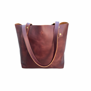 Brown leather tote bag, bucket style with two straps on transparent background