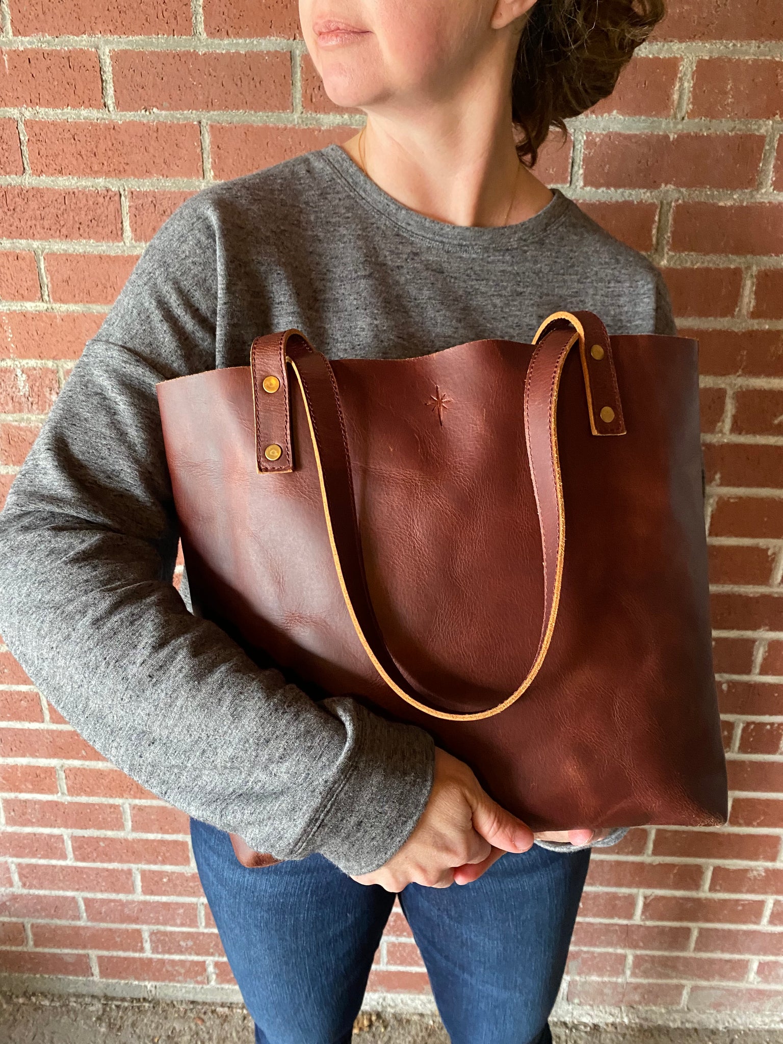 Girl holding brown leather tote bag